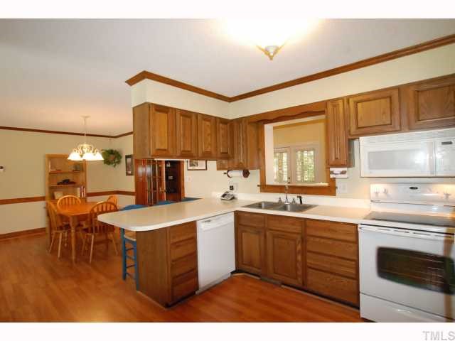 7516 Deer Track Drive Raleigh, NC 27613 - Photo 5 of 11 Kitchen with Breakfast Bar, Generous Double Door Pantry Closet & Laminate Flooring.