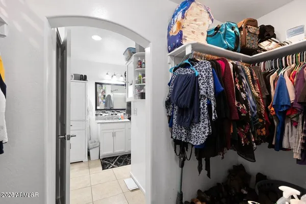 a view of walk in closet with clothes and shoes
