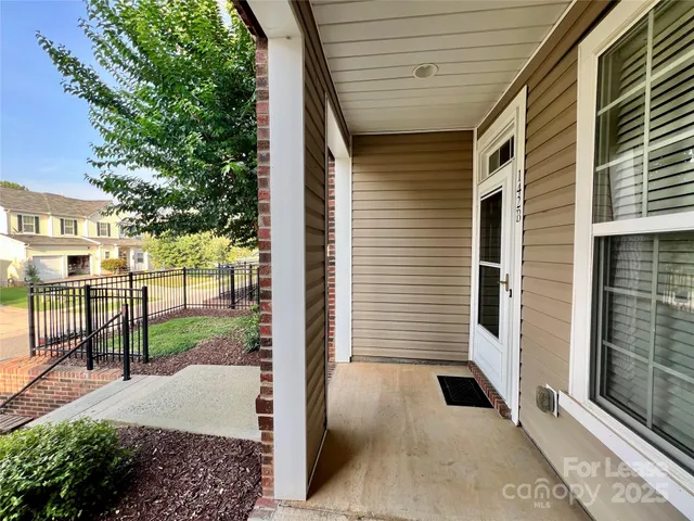 a view of a porch with a floor to ceiling window and wooden fence