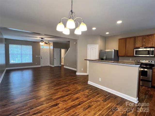a view of a kitchen with stove and wooden floor