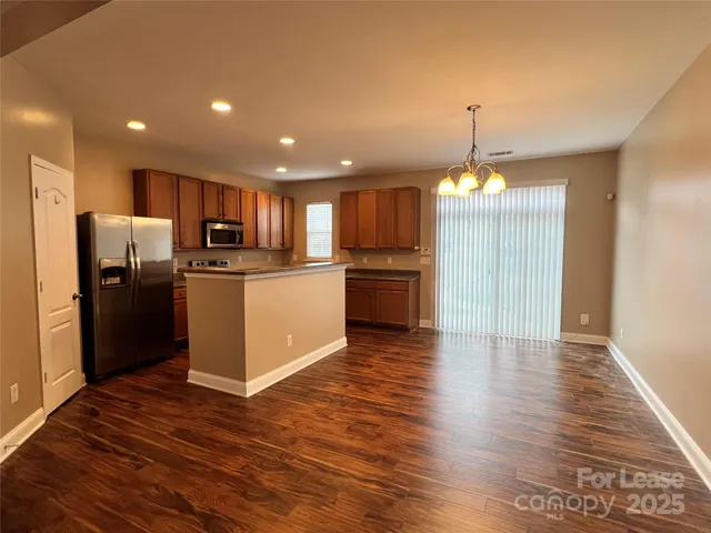 a view of kitchen with refrigerator microwave and wooden floor