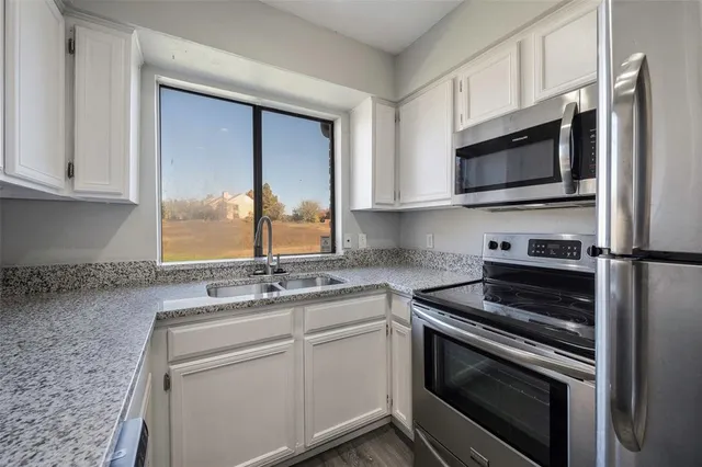 a kitchen with a sink stove and microwave