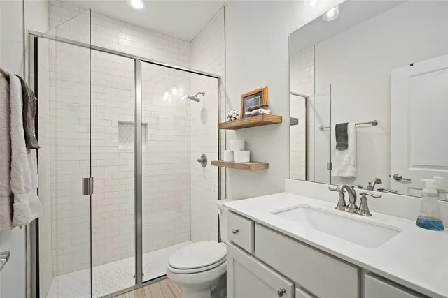 a bathroom with a granite countertop sink a toilet and shower