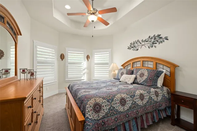 a bedroom with a bed a dresser and potted plants