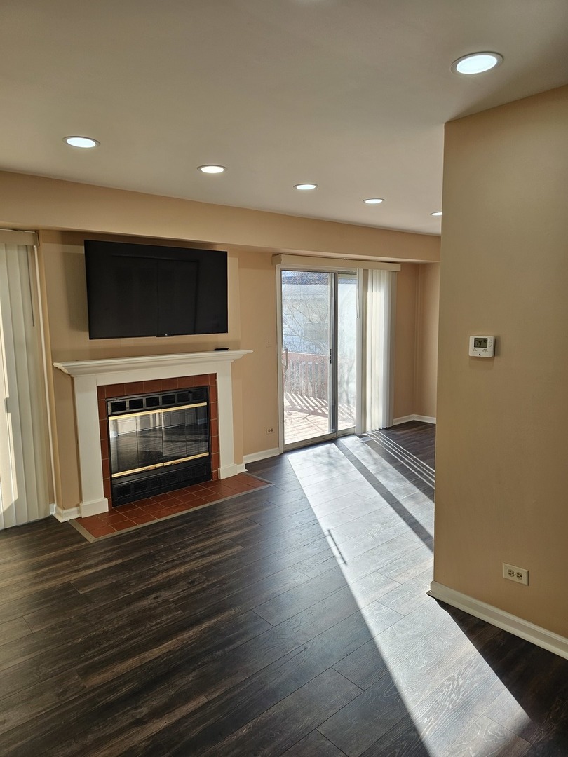 1529 Lighthouse Drive Naperville, IL 60565 - Photo 5 of 21 a view of an empty room with wooden floor and a fireplace
