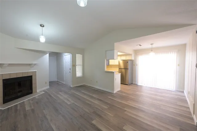 a view of empty room with wooden floor and fireplace