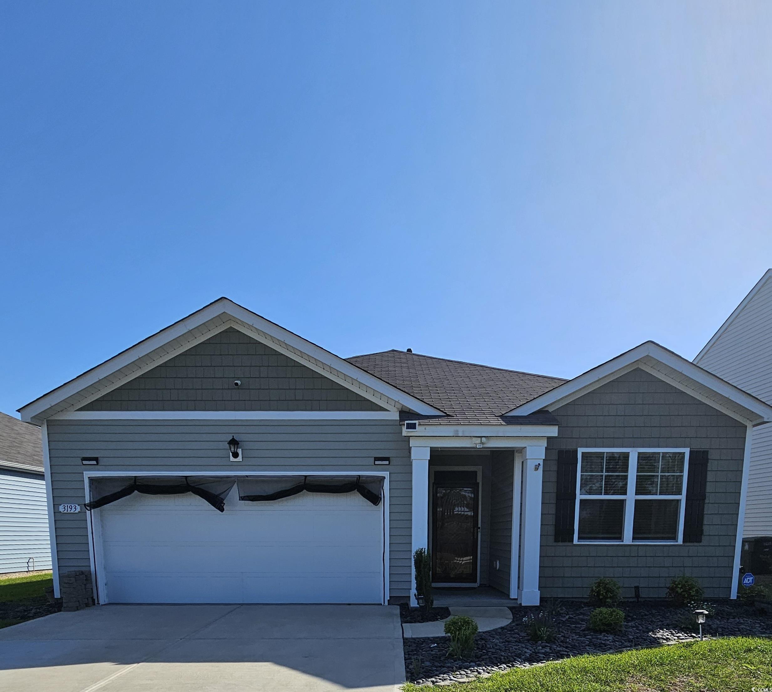 Ranch-style home featuring concrete driveway, an attached garage, and a shingled roof