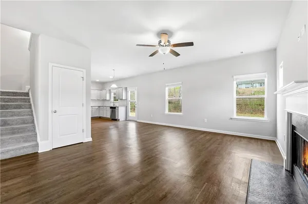a view of empty room with wooden floor and window