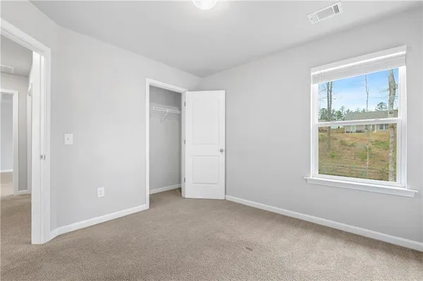 an empty room with windows and closet