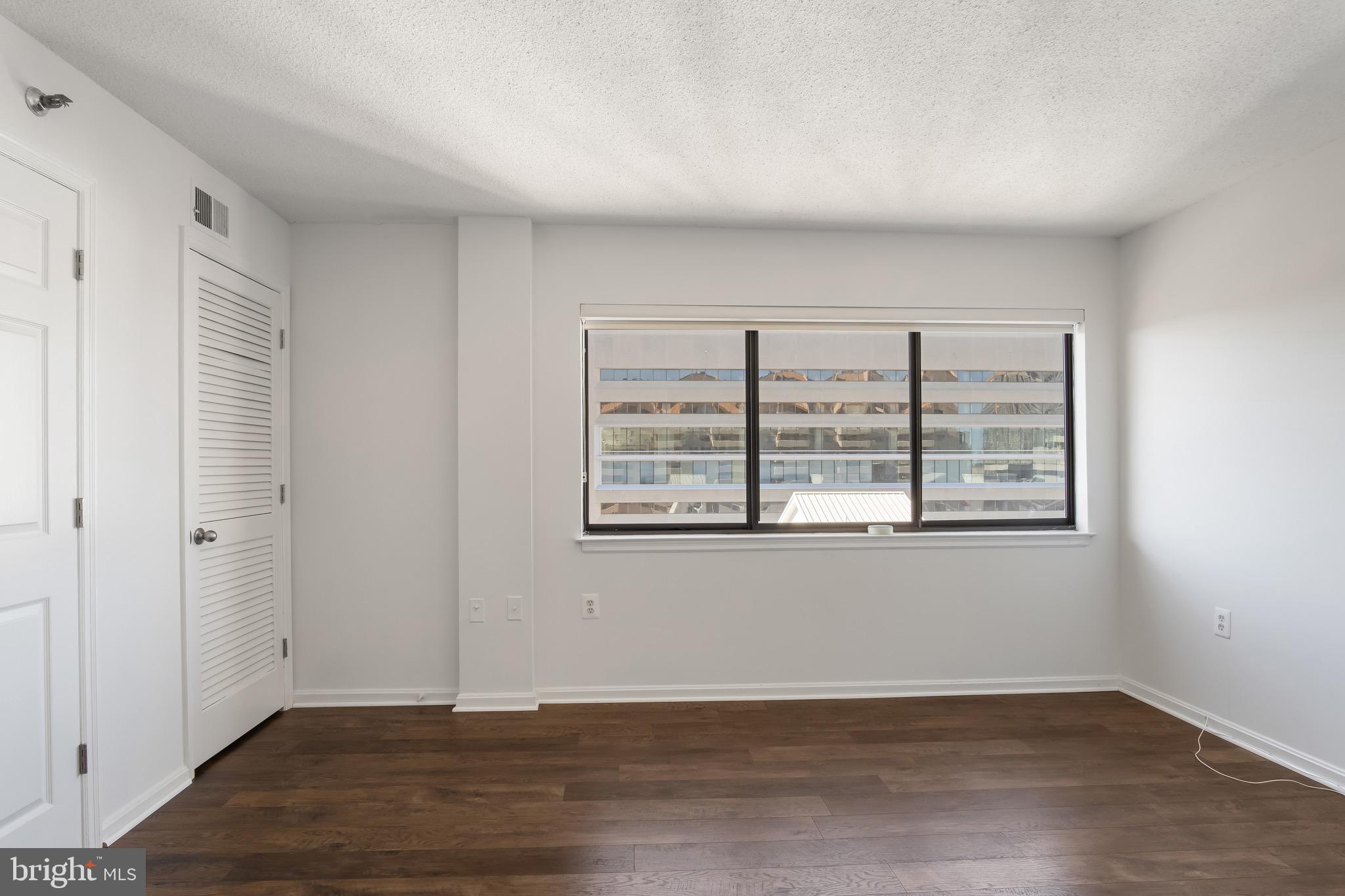 1301 North Courthouse Road, Unit 1401 Arlington, VA 22201 - Photo 11 of 34 a view of an empty room with wooden floor and a window