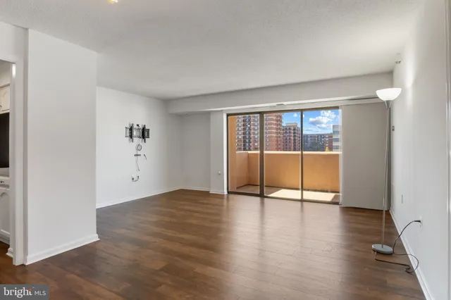 a view of a room with wooden floor and a ceiling fan