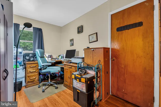 a view of a workspace with furniture and a window