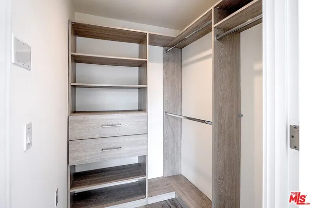 a view of walk in closet with empty racks