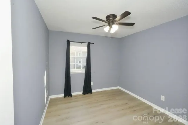 an empty room with closet and a ceiling fan