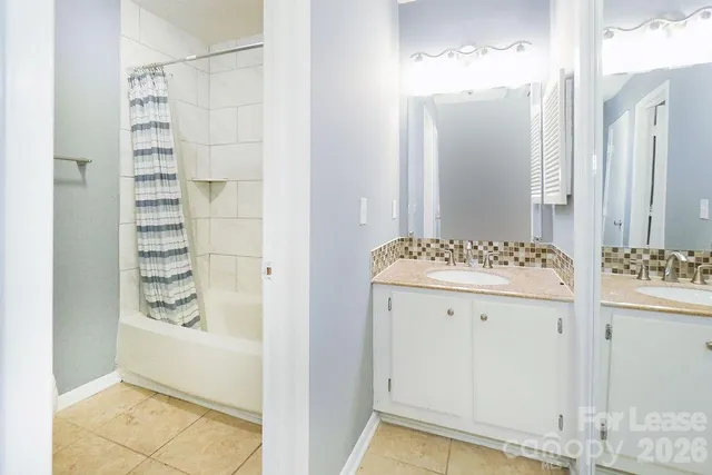 a bathroom with a granite countertop sink a mirror and a shower