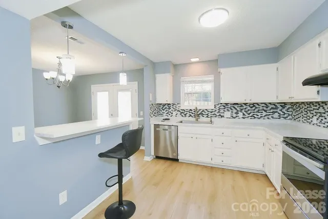 a spacious bathroom with a granite countertop sink a mirror and a bathtub