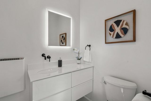 a bathroom with a toilet sink and mirror