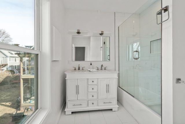 a bathroom with a granite countertop sink a mirror and a shower