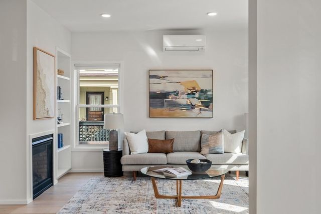 a living room with furniture a fireplace and a window