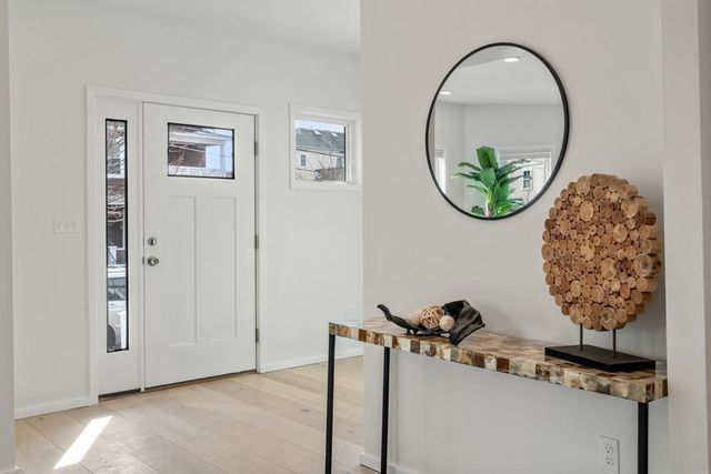 an entryway with wooden floor and glass door
