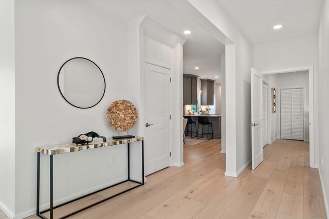 a view of a hallway to rooms and wooden floor
