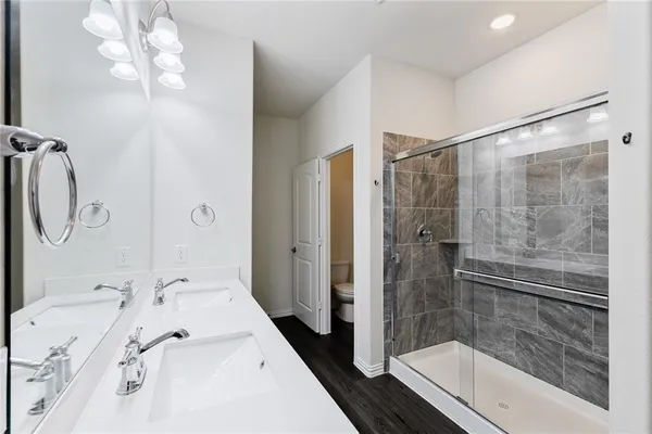 a bathroom with a tub shower sink and mirror