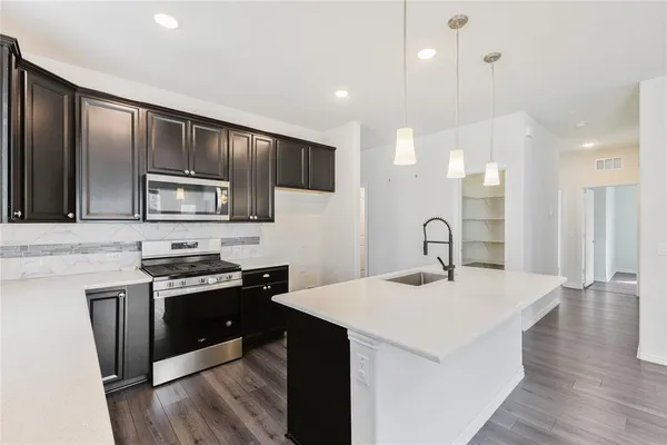 a kitchen with stainless steel appliances kitchen island a sink stove and cabinets