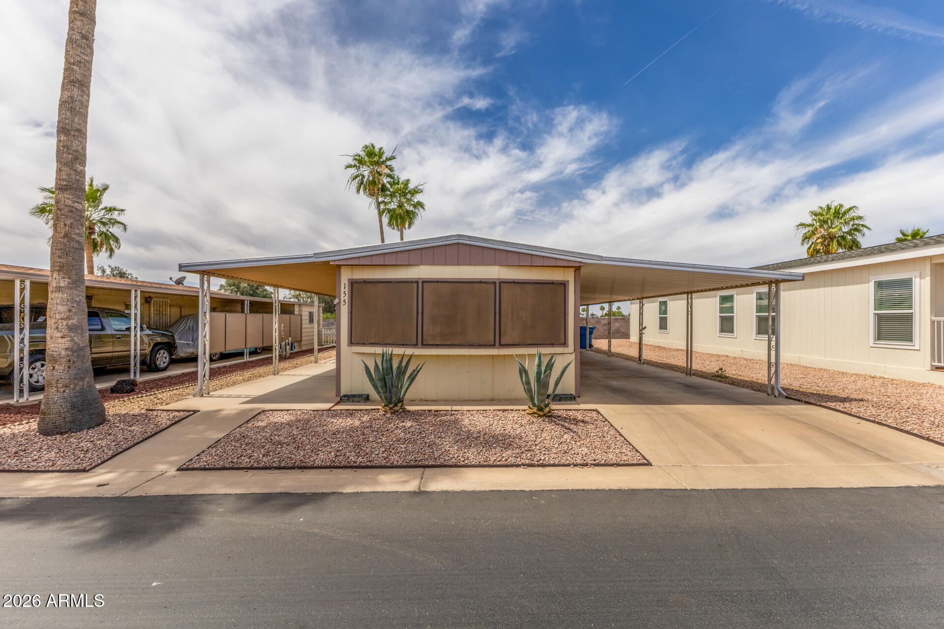 9302 East Broadway Road, Unit 155 Mesa, AZ 85208 - Photo 1 of 26 a front view of a house with a yard and potted plants