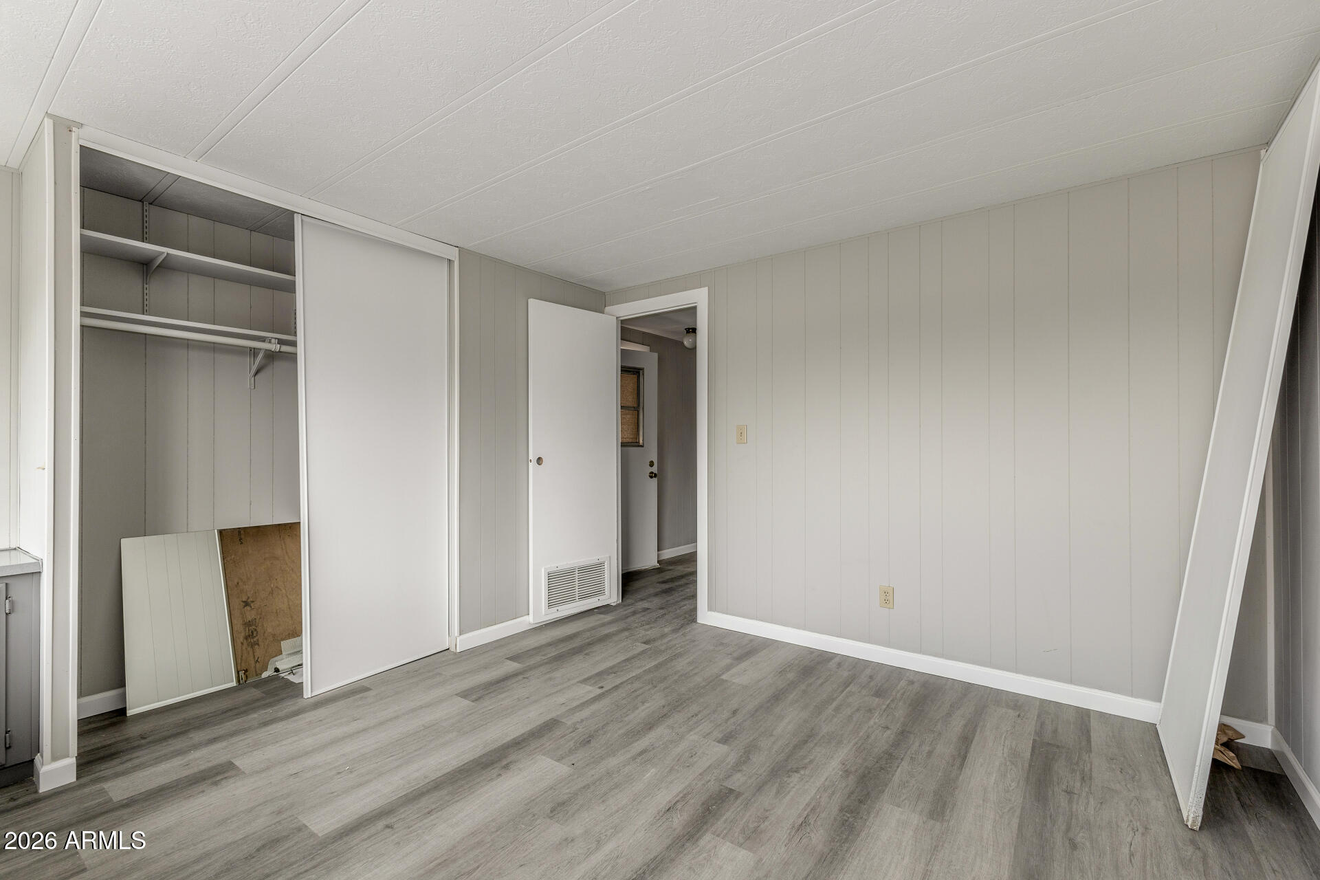 9302 East Broadway Road, Unit 155 Mesa, AZ 85208 - Photo 13 of 26 a view of an empty room with wooden floor and closet
