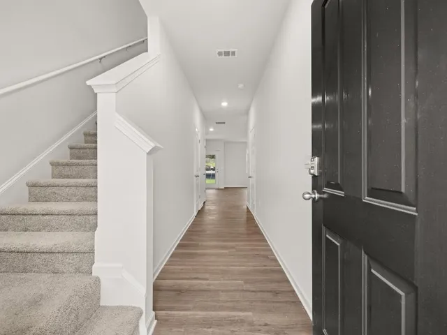 a view of a hallway with the wooden floor and staircase