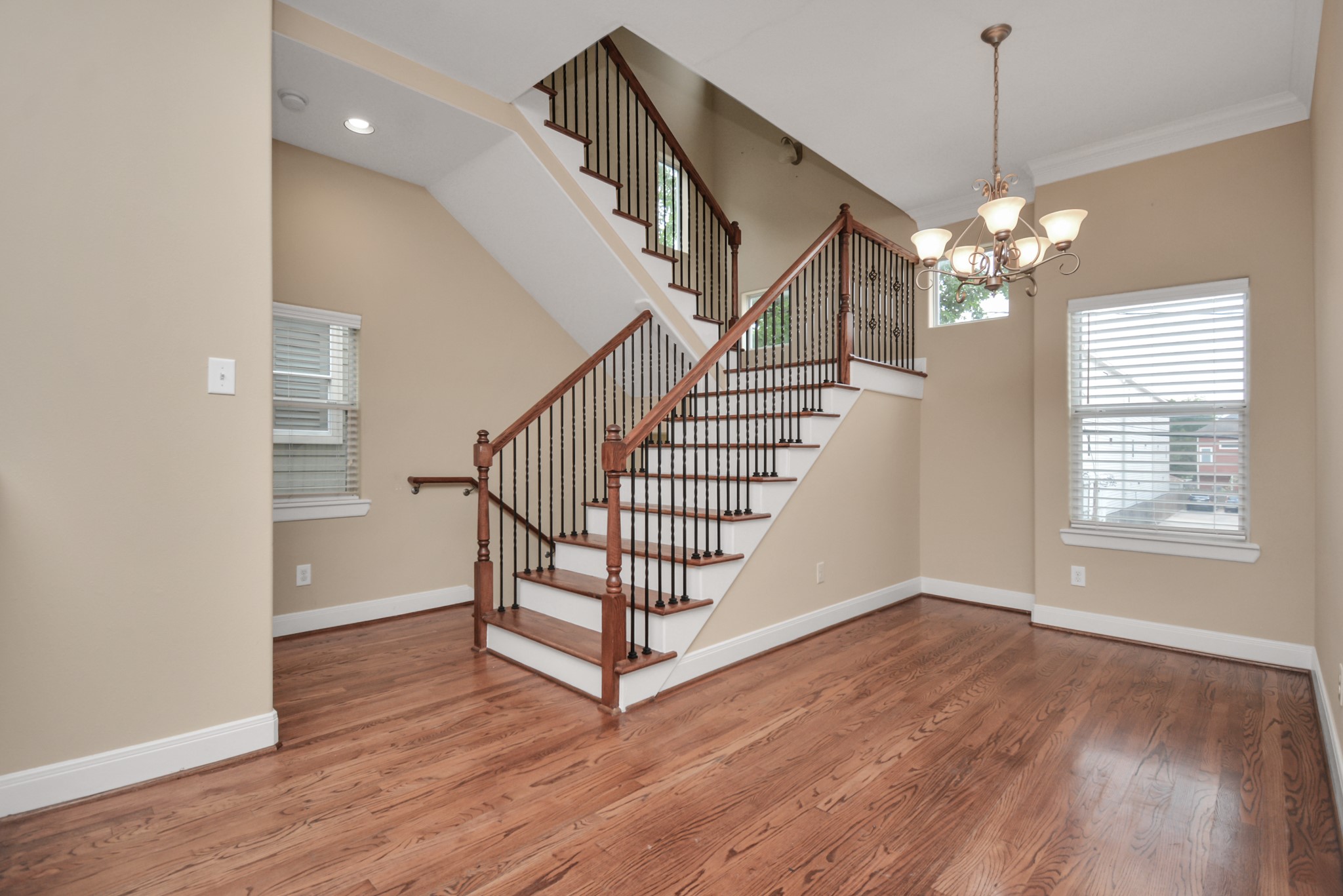 1137 West 24th Street, Unit A Houston, TX 77008 - Photo 6 of 40 a view of a livingroom with wooden floor stairs and a chandelier