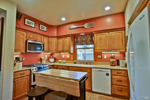 a kitchen with stainless steel appliances kitchen island granite countertop a sink and cabinets