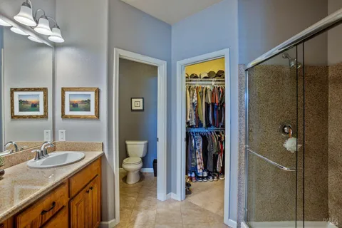 a en suite bathroom with a granite countertop sink toilet and shower