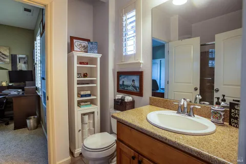 a bathroom with a granite countertop sink toilet and shower