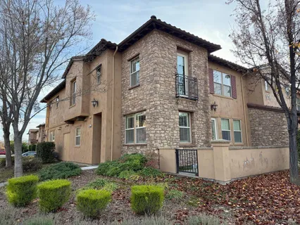 a view of a house with a yard and large tree