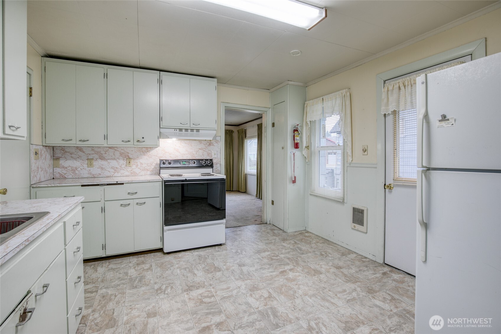 1019 Maple Street Hoquiam, WA 98550 - Photo 9 of 21 a kitchen with granite countertop white cabinets and refrigerator
