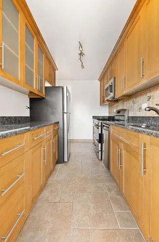 a kitchen with stainless steel appliances granite countertop a stove a sink and a refrigerator