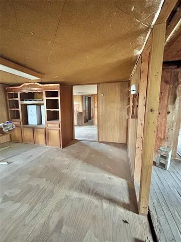 a view of a hallway with wooden floor and furniture