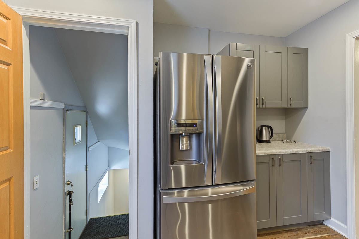 2544 East 91st Street Chicago, IL 60617 - Photo 12 of 37 a view of a refrigerator in kitchen and an empty room with wooden floor windows