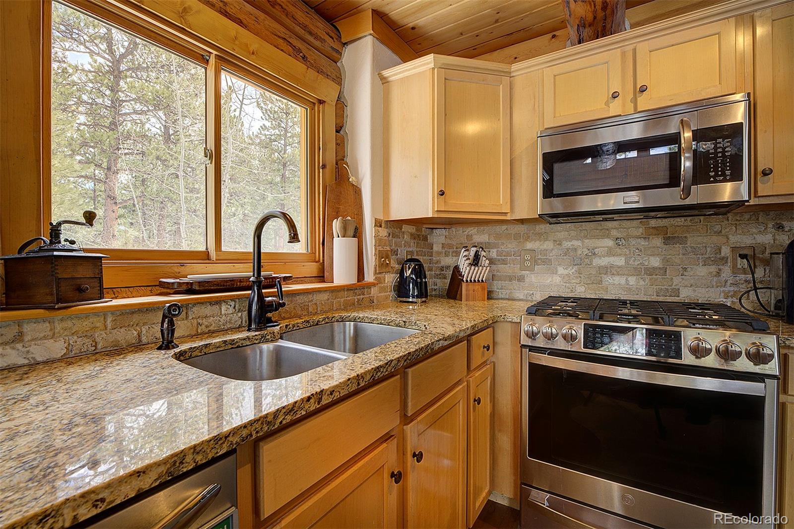 58 Conestoga Court Bailey, CO 80421 - Photo 12 of 37 a kitchen with granite countertop a sink a stove and microwave