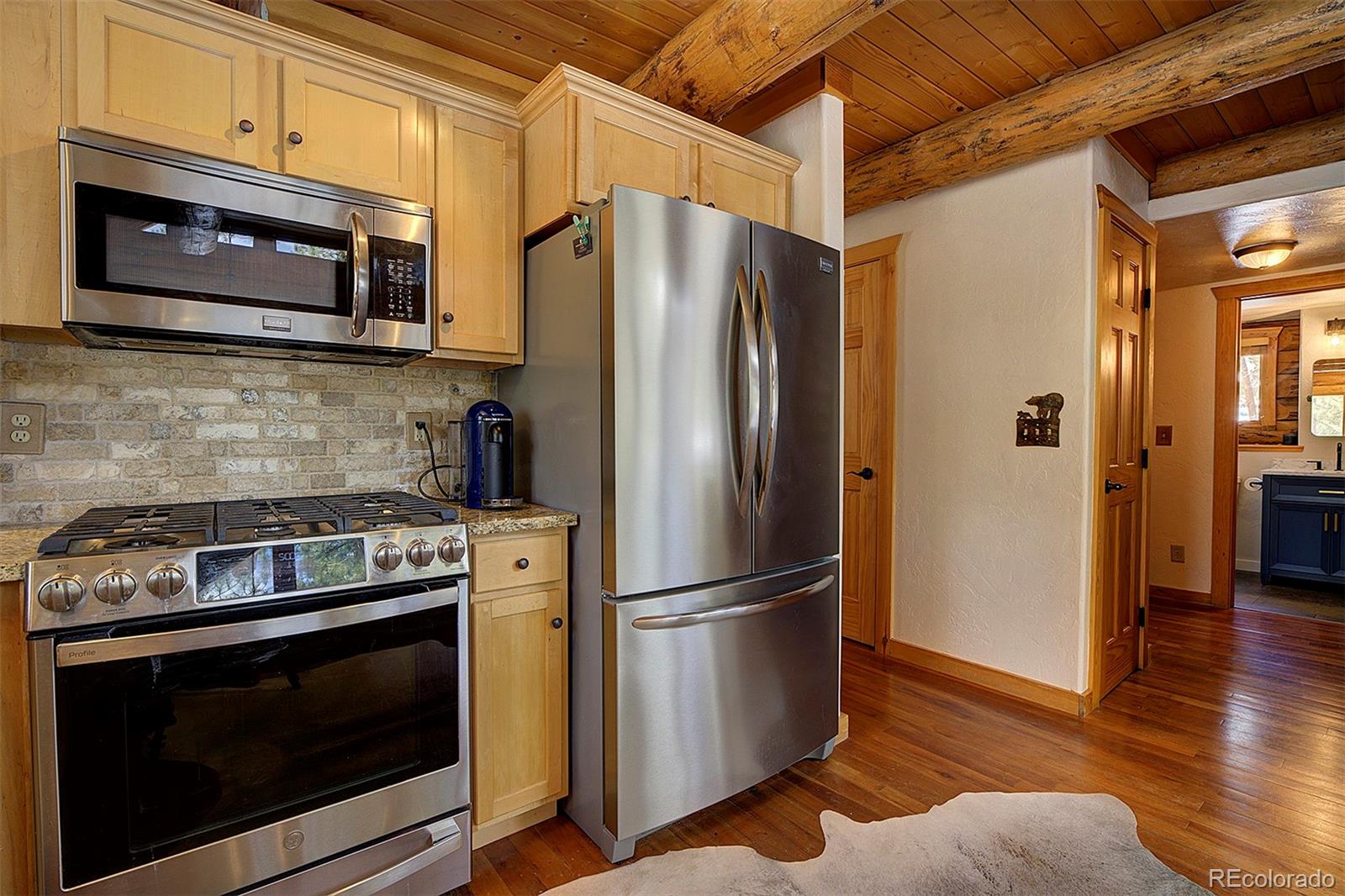58 Conestoga Court Bailey, CO 80421 - Photo 9 of 37 a kitchen with stainless steel appliances granite countertop a refrigerator microwave and stove top oven