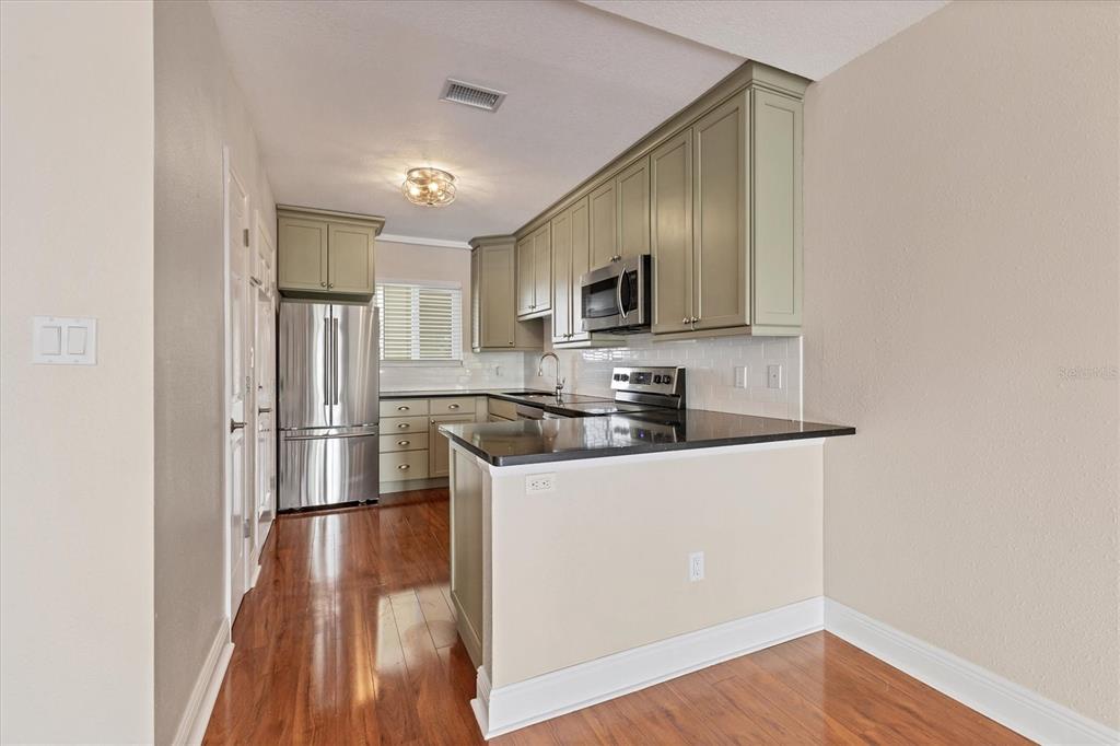 301 South Gulfstream Avenue, Unit 302 Sarasota, FL 34236 - Photo 12 of 25 a kitchen with stainless steel appliances granite countertop a refrigerator a stove top oven a sink and dishwasher