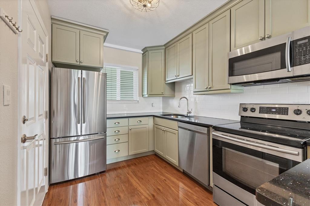 301 South Gulfstream Avenue, Unit 302 Sarasota, FL 34236 - Photo 14 of 25 a kitchen with granite countertop a refrigerator stove and microwave