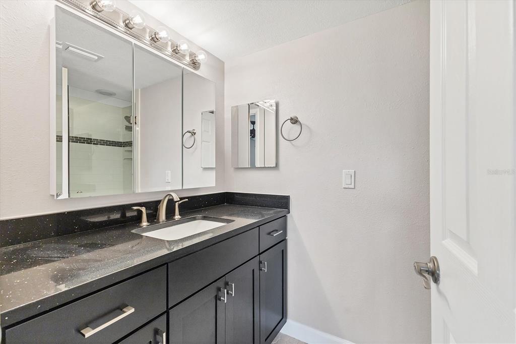 301 South Gulfstream Avenue, Unit 302 Sarasota, FL 34236 - Photo 21 of 25 a bathroom with a granite countertop sink and a mirror