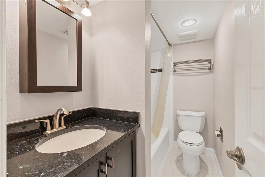 301 South Gulfstream Avenue, Unit 302 Sarasota, FL 34236 - Photo 24 of 25 a bathroom with a granite countertop sink toilet and mirror