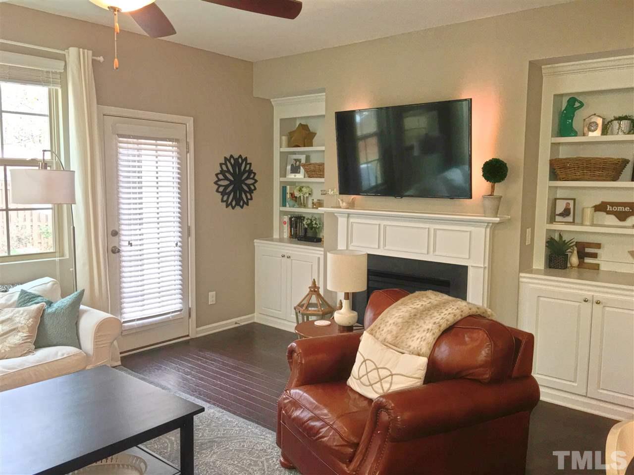 724 Wickham Ridge Road Apex, NC 27539 - Photo 14 of 22 a living room with furniture a flat screen tv and a fireplace