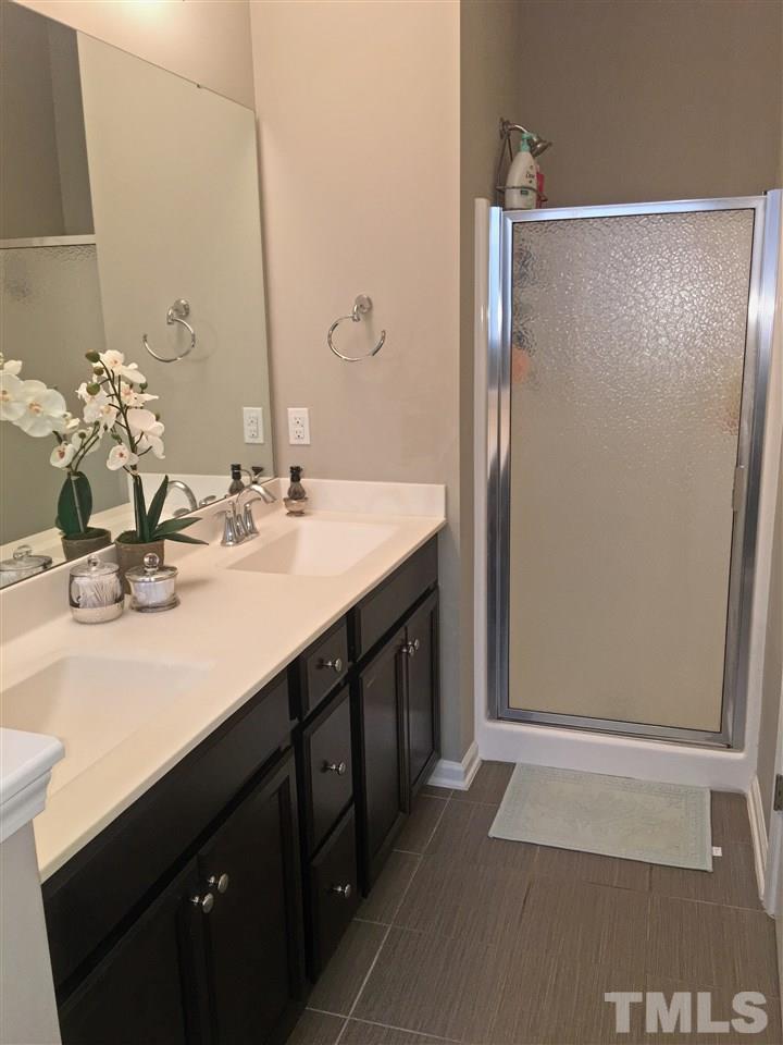 724 Wickham Ridge Road Apex, NC 27539 - Photo 22 of 22 a bathroom with a double vanity sink and a mirror