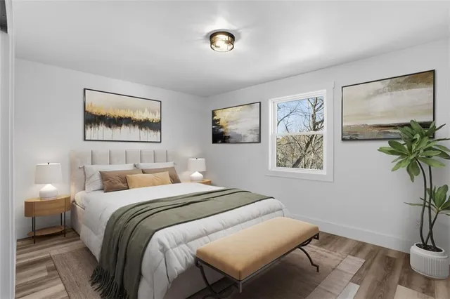 a bedroom with a bed and a painting on the wall