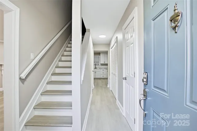 a view of a hallway with wooden floor and staircase