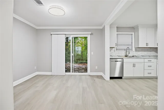 a view of a kitchen with wooden floor and electronic appliances